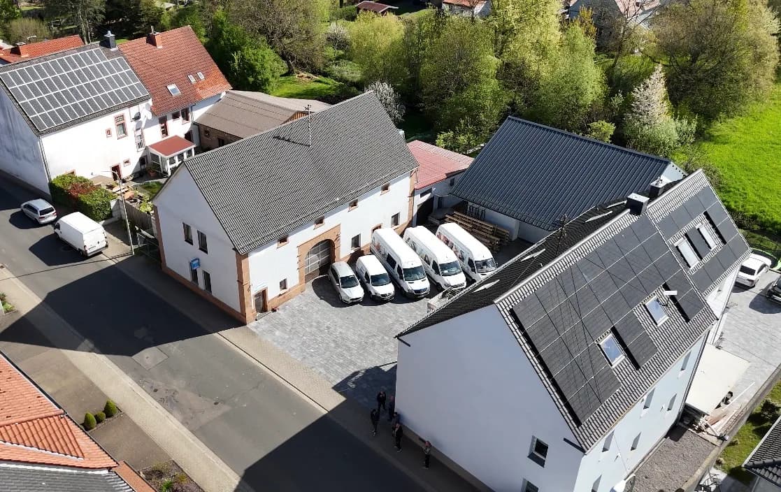 Betriebshof der AN Treppenbau GmbH in Herschweiler-Pettersheim aus der Luft, mit Werkstatthalle und Firmenfahrzeugen im Hof